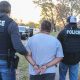 Agentes federales de ICE arrestando a un inmigrante, representando el aumento de detenciones a latinos sin antecedentes penales.